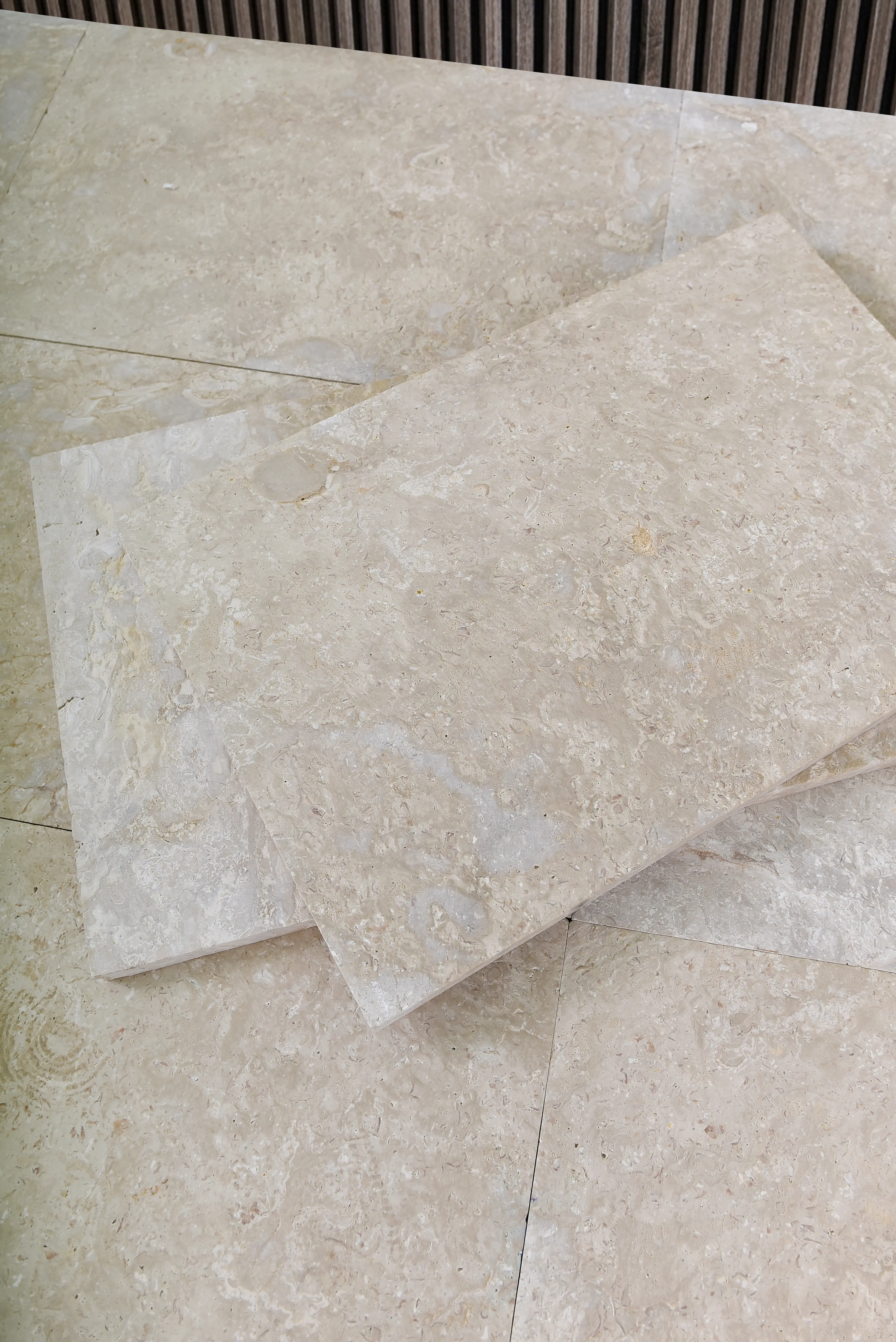 Light beige travertine stone slabs showcasing natural porous texture and veining for flooring, an example for diy stepping stones.