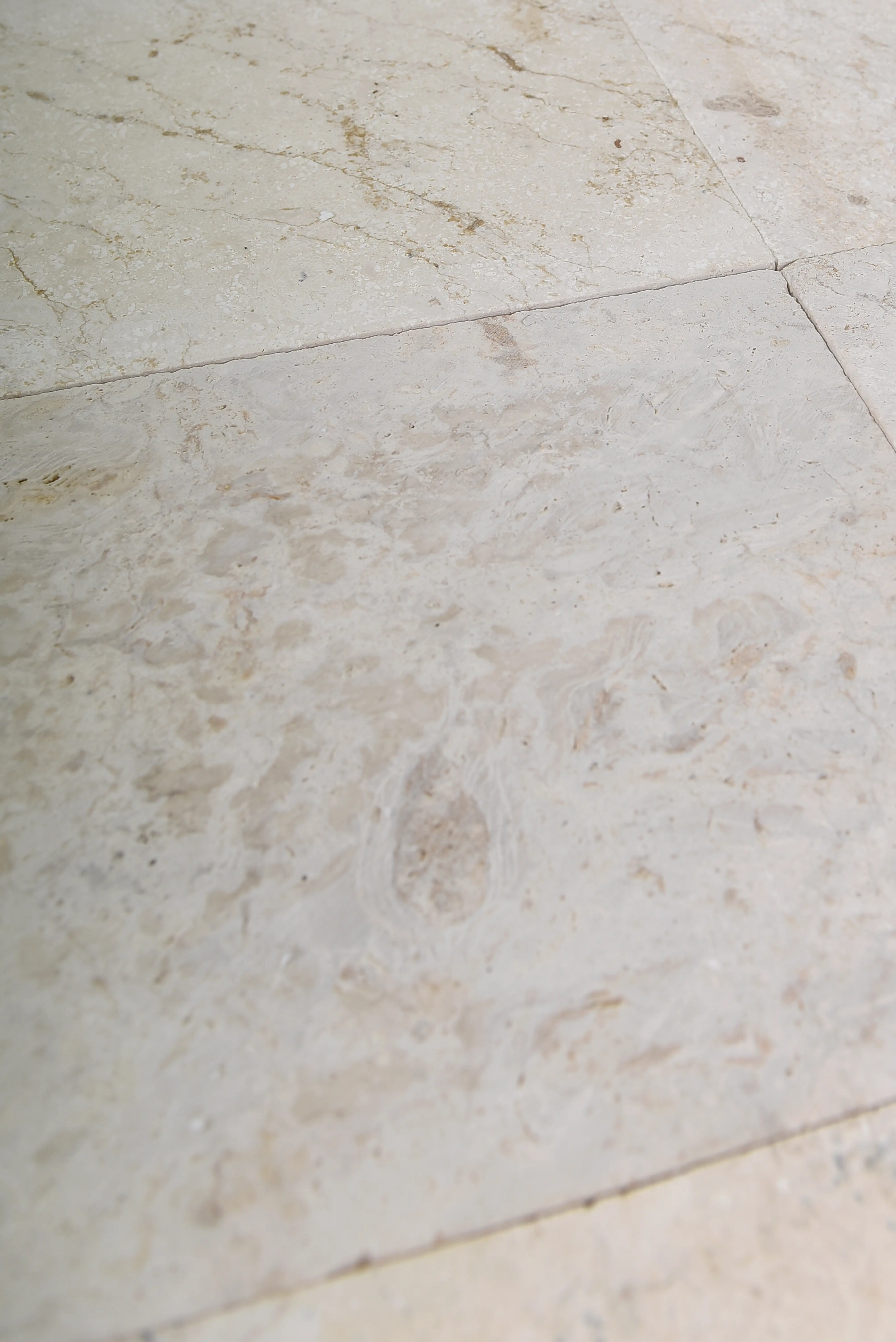 Beige marble tile texture Close-up view of beige marble floor tiles showing natural veining and subtle texture variations, relevant to stone garden wall ideas.