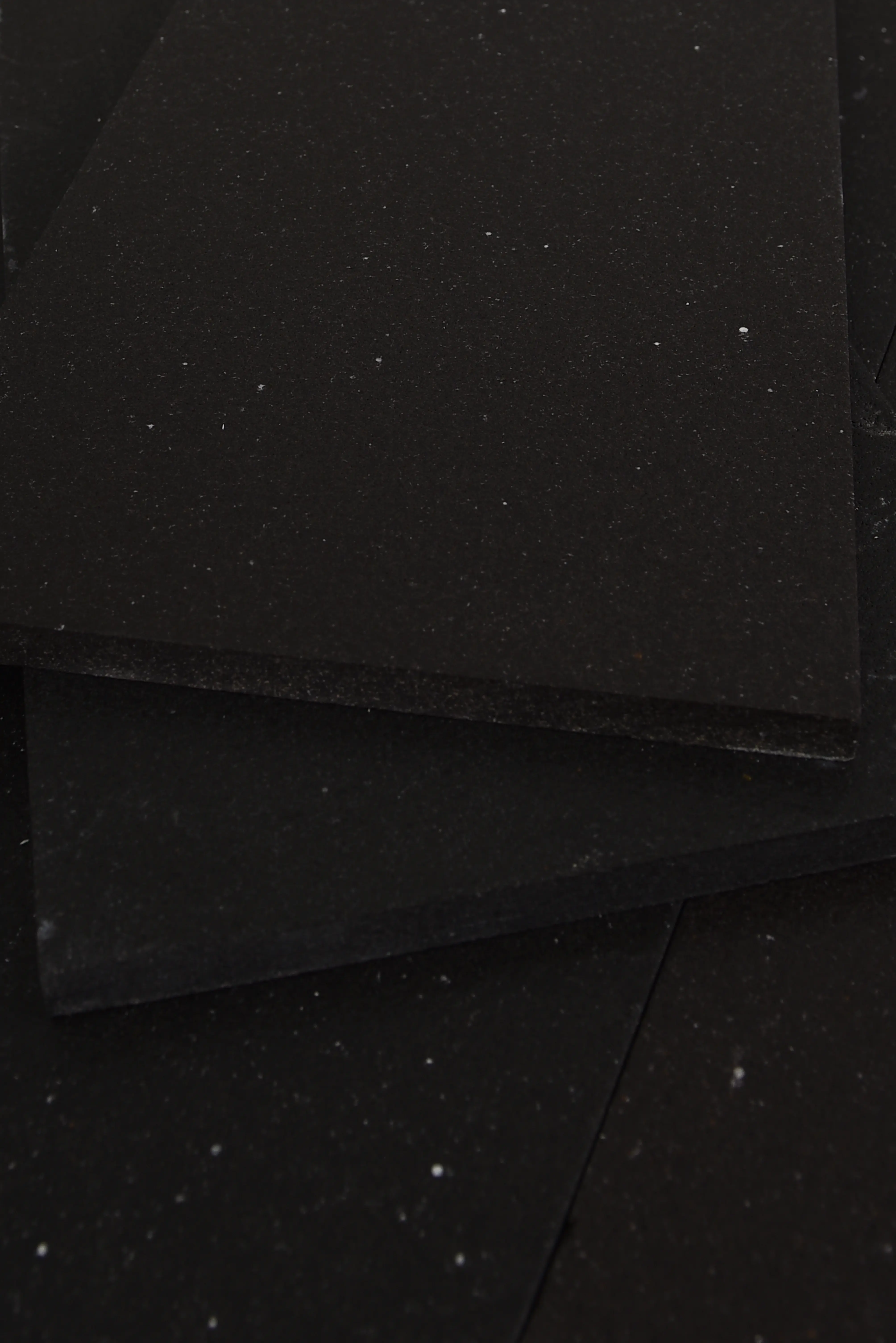 Close-up view of dark granite pavers showing subtle speckled texture, pictured for how to cut paving stones.
