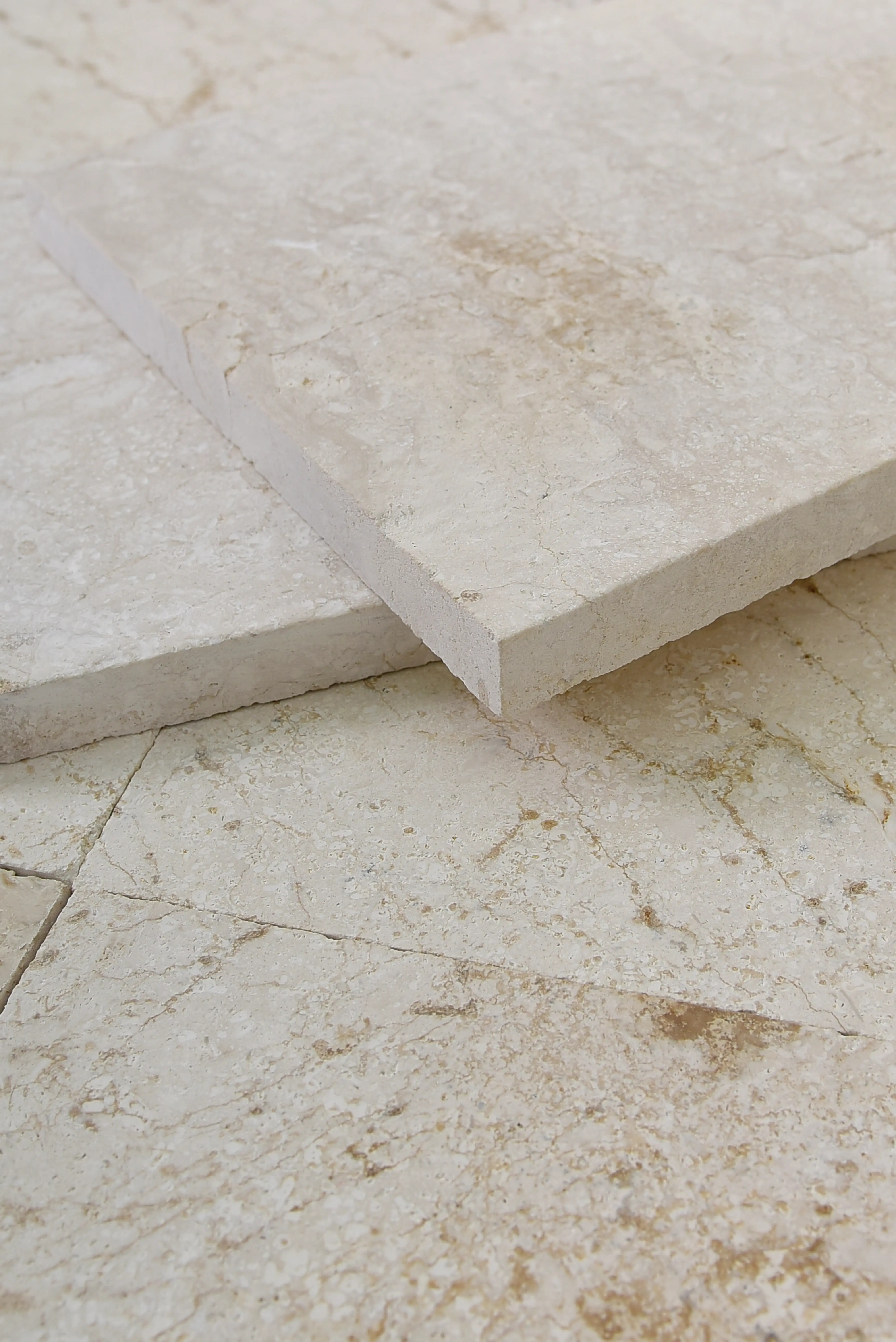 Close-up view of cream limestone tiles showcasing subtle veining and textured surface, relevant to black stone suppliers.
