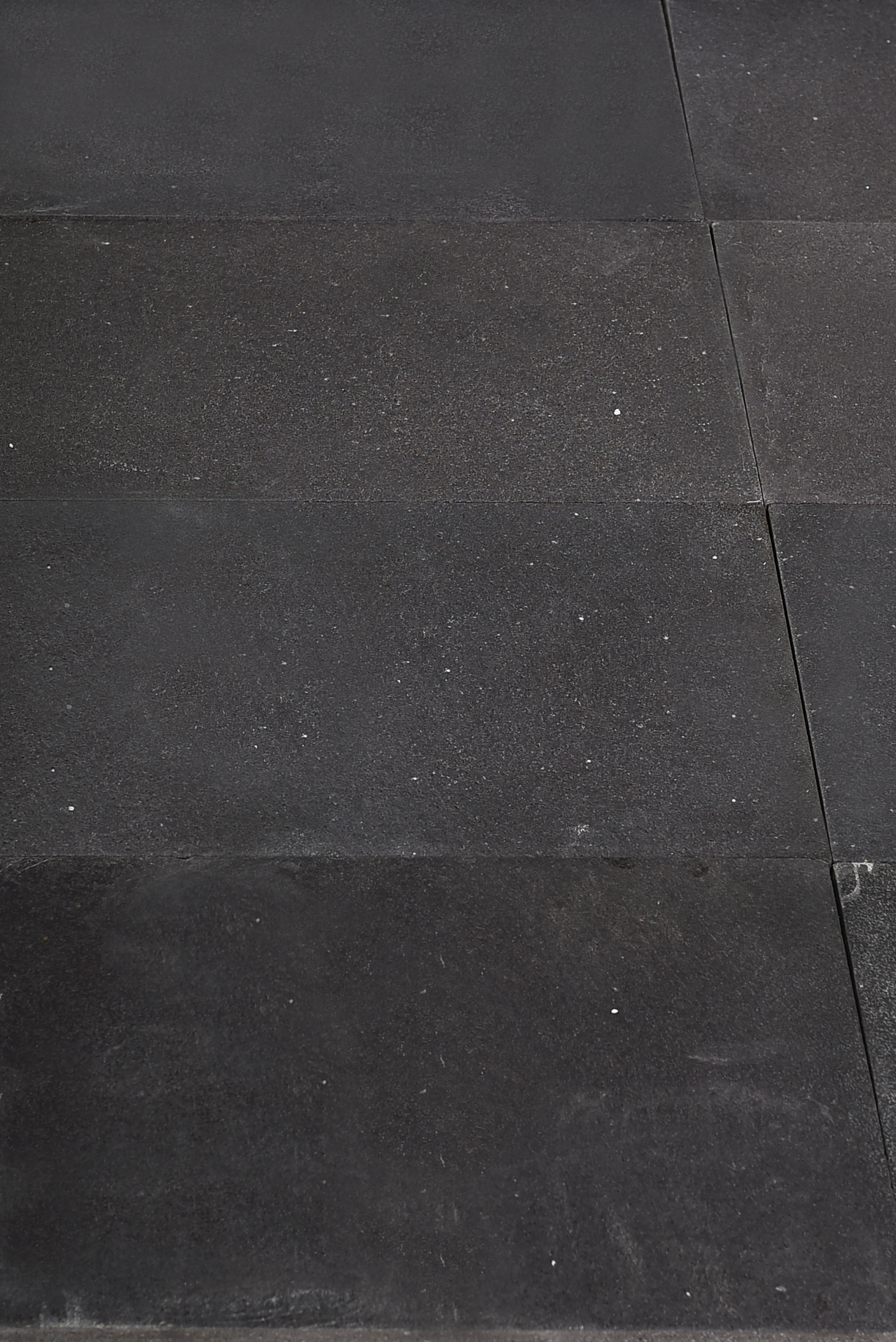 Dark Paving Stone Surface Close-up texture of dark bluestone pavers showing subtle speckling and texture, a reference for how to choose bluestone grade.