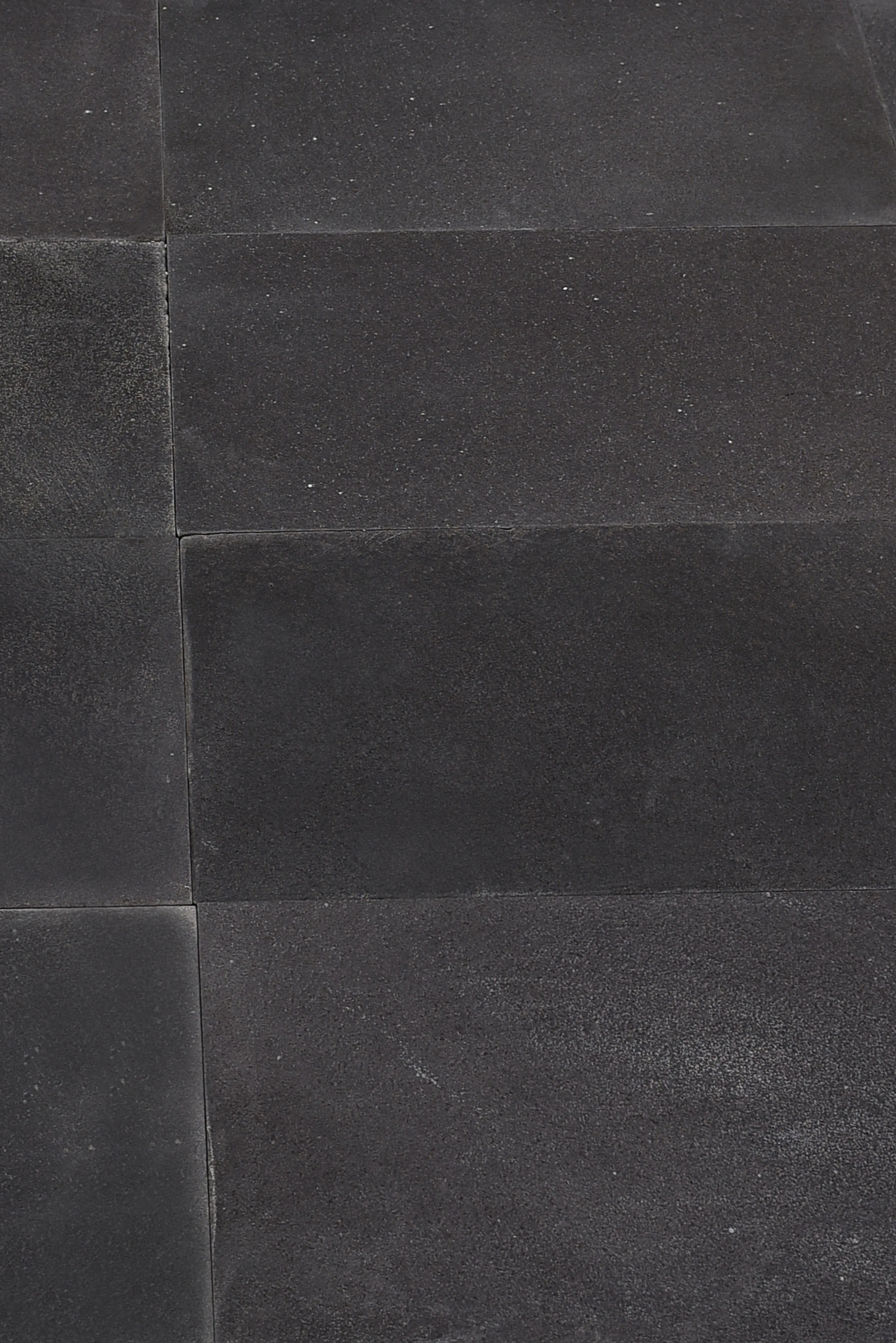 Blue limestone paving slabs in a honed charcoal finish laid across a contemporary patio