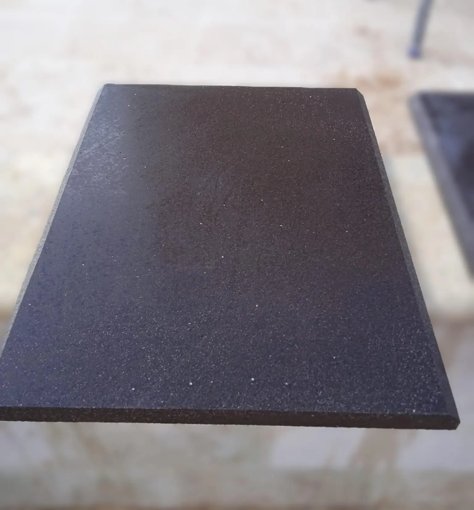 Close-up view of a dark speckled travertine pavers slab surface texture, a reference for indoor travertine tile.
