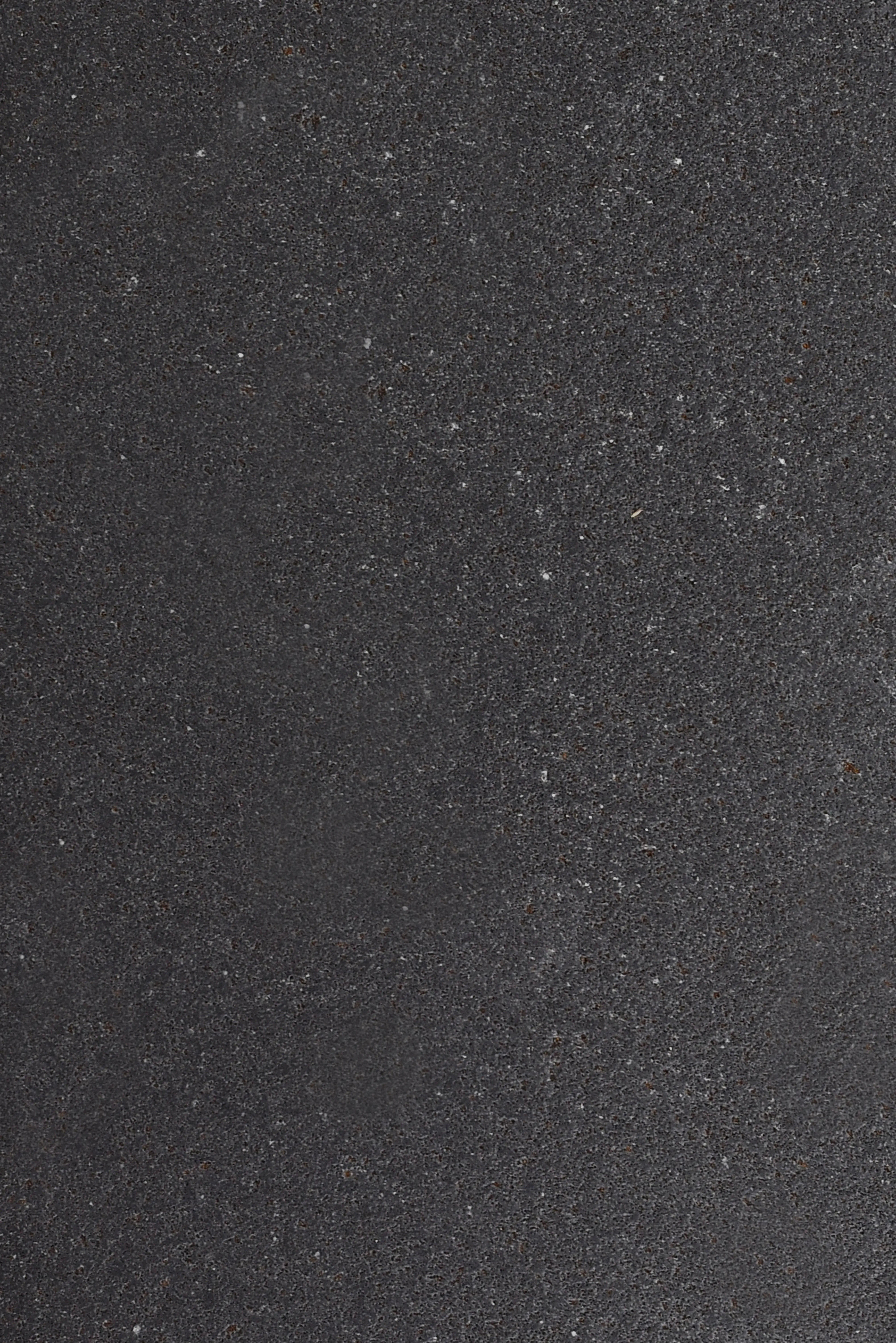 Close-up view of a dark charcoal travertine surface texture with subtle speckles, pictured for sealer for travertine.