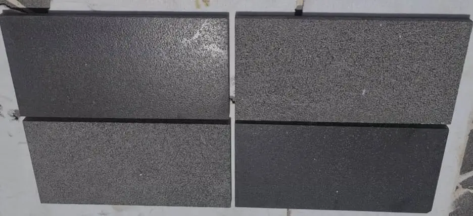 Four dark basalt pavers with a textured surface arranged in two columns, a reference for granite outdoor bench.
