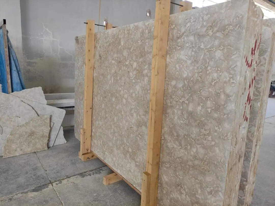 Large polished limestone slabs are stacked and supported by wooden frames, a reference for low maintenance front yard rock landscaping.