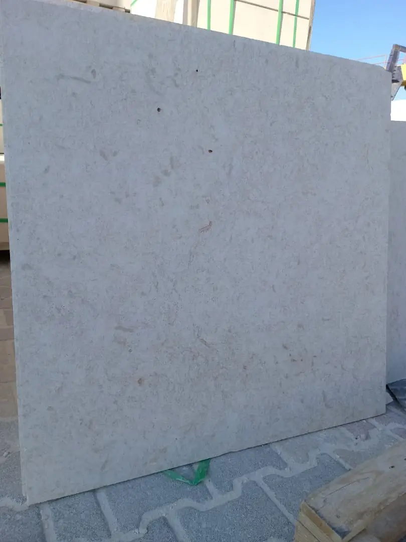 Close-up of a light beige limestone slab with subtle natural variations and pores, pictured for granite landscape rock color comparison.