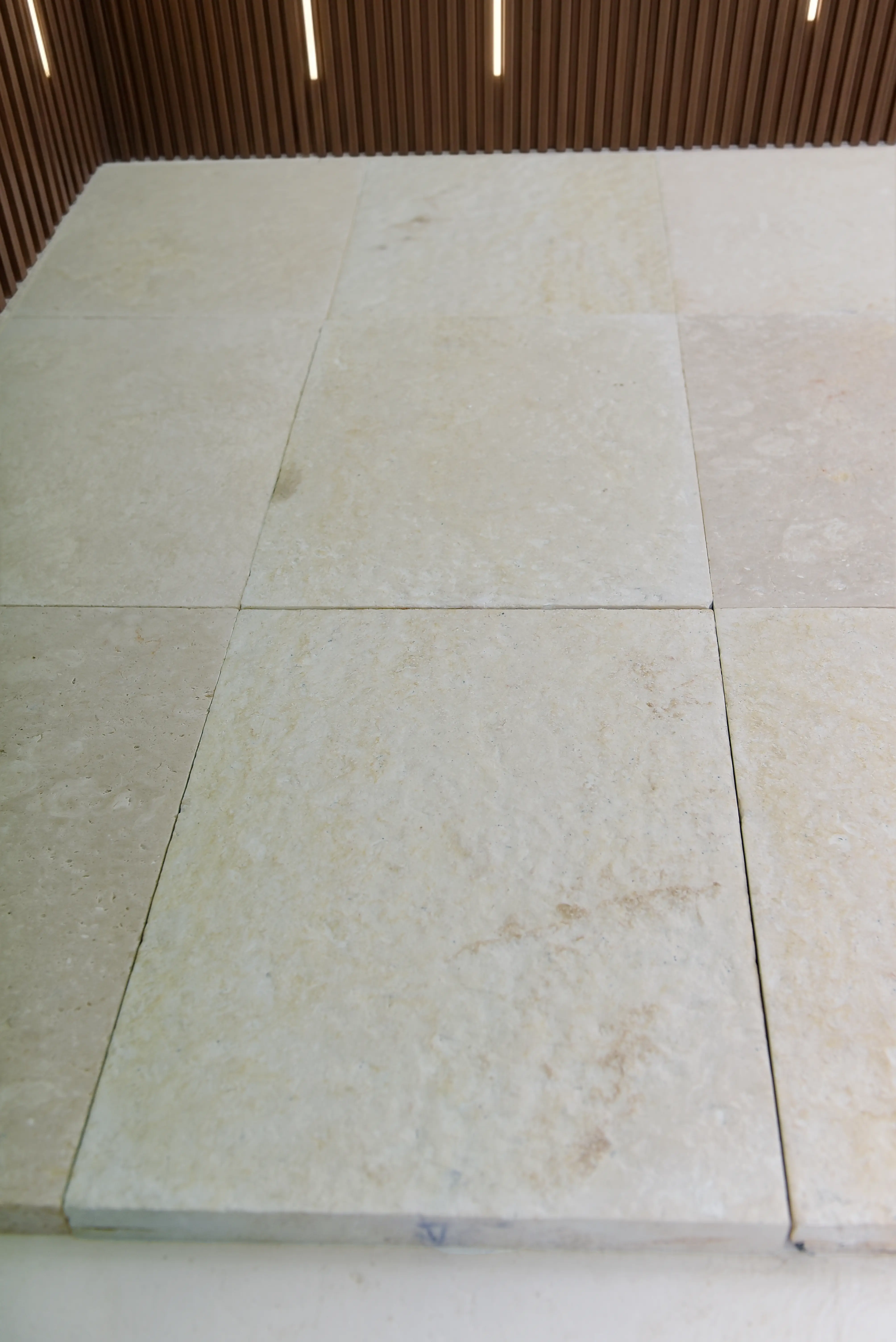 Light Stone Floor Tiles Neutral light-colored stone floor tiles with subtle veining, showcasing a clean modern surface, pictured for stone steps in grass.