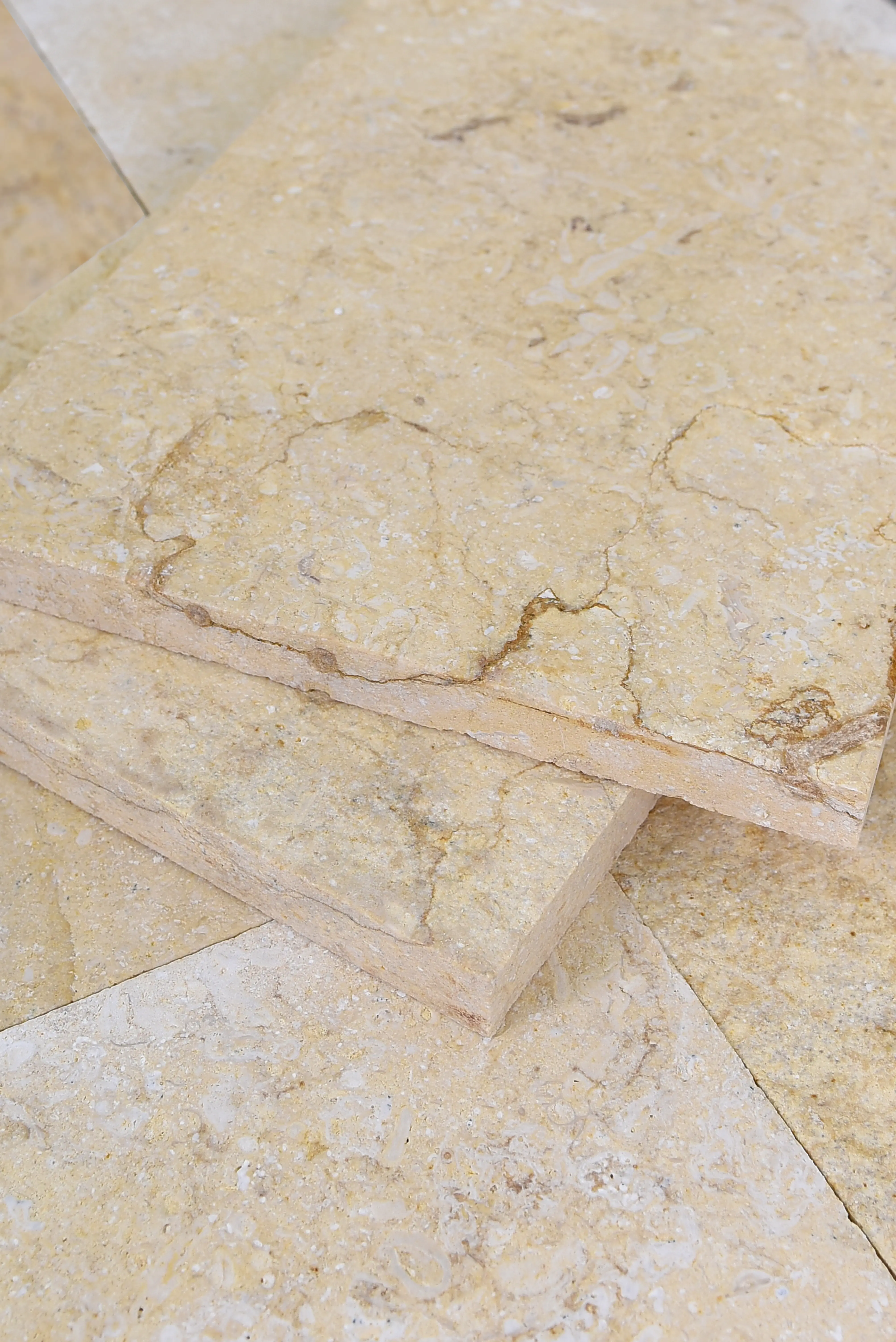 Close-up view of light tan limestone tiles with natural veining and texture, pictured for stone on masonry.