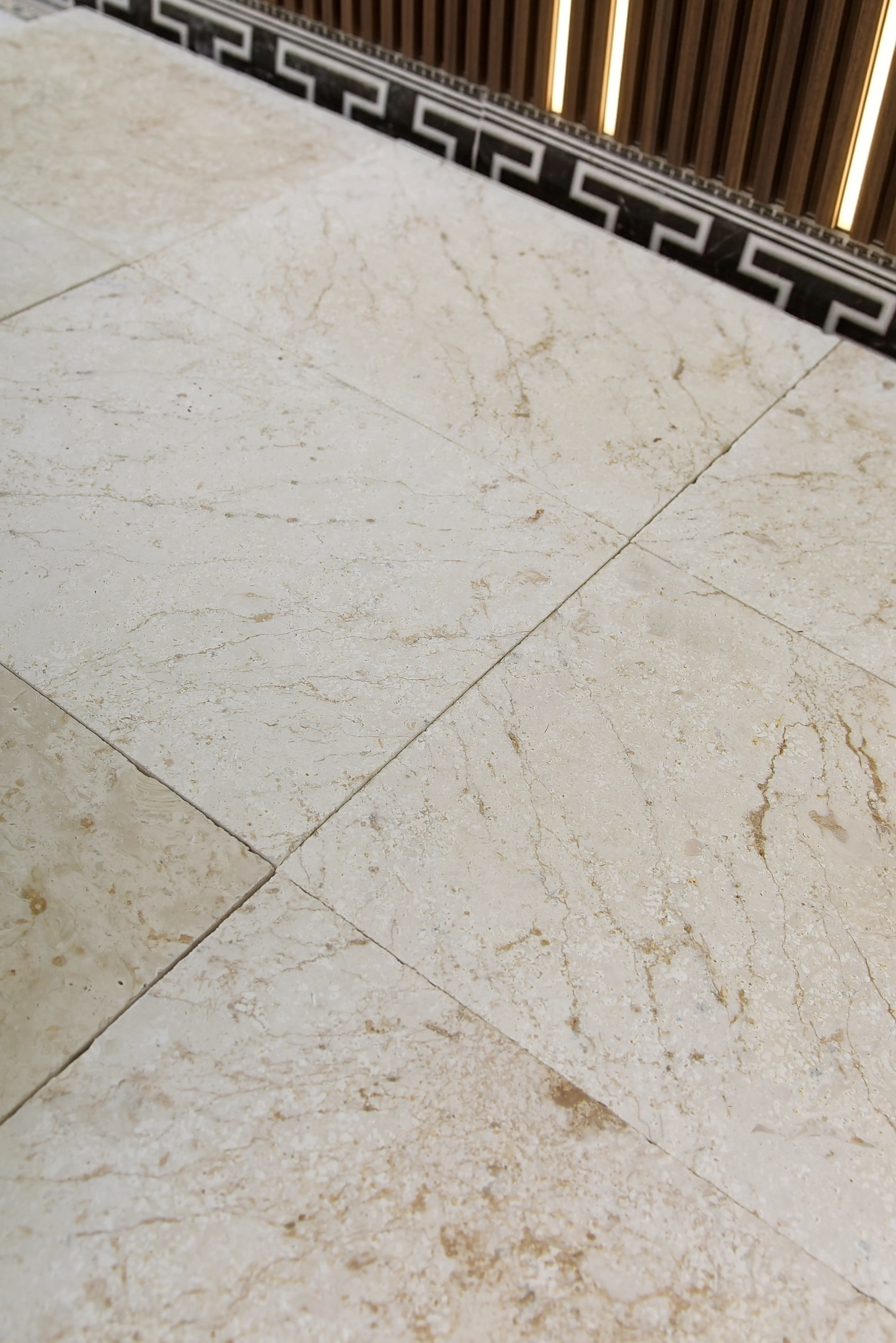 Light beige marble floor tiles Close-up of light beige marble floor tiles with natural veining and texture, a reference for sintered stone suppliers.