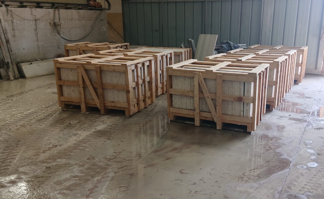 Natural-Stone-Distribution-Facility-Storage-Overview Distribution facility warehouse displaying stacked reinforced wooden crates containing stone materials for choosing stone slabs for steps.