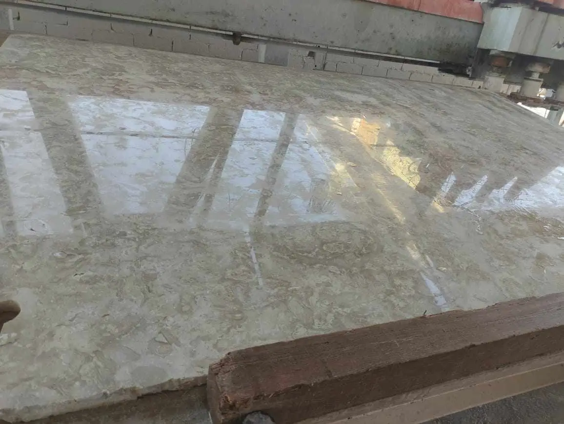 Polished Marble Slab Reflection Smooth polished marble slab reflecting overhead lights in a workshop setting, pictured for install stone window sills.
