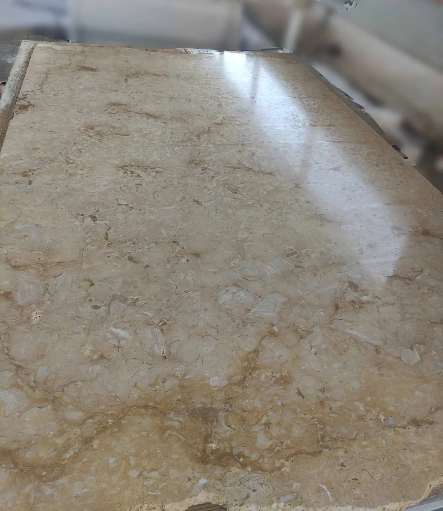 Polished beige travertine marble slab showcasing intricate natural veining and patterns, pictured for how to choose masonry stone contractor.