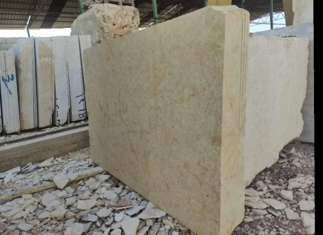 Large raw travertine blocks are stacked and cut, showcasing their rough texture and earthy tones, an example for travertine coping.