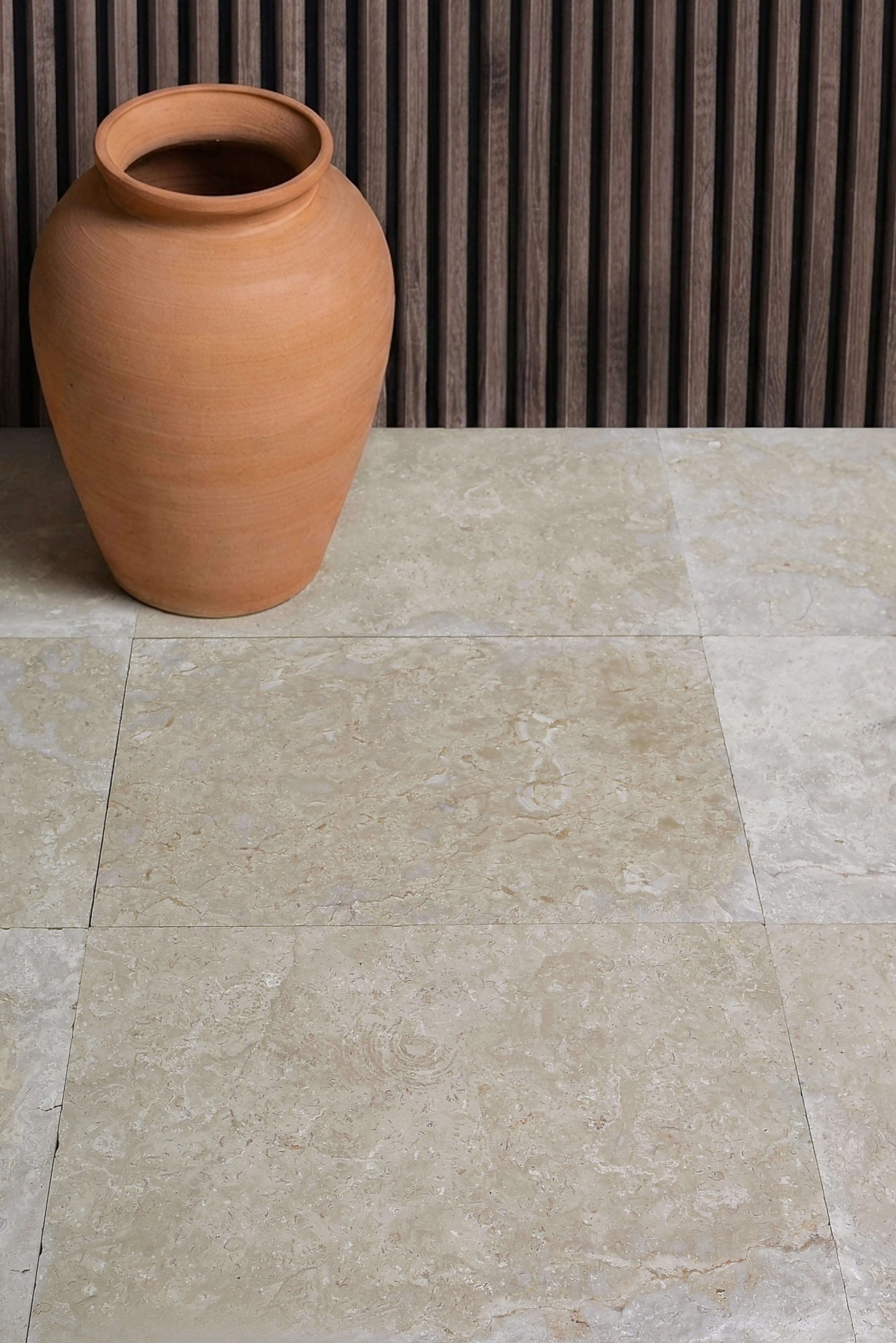 Close-up of light travertine pavers with a terracotta pot for interior design, pictured for Masonry Stone Suppliers.
