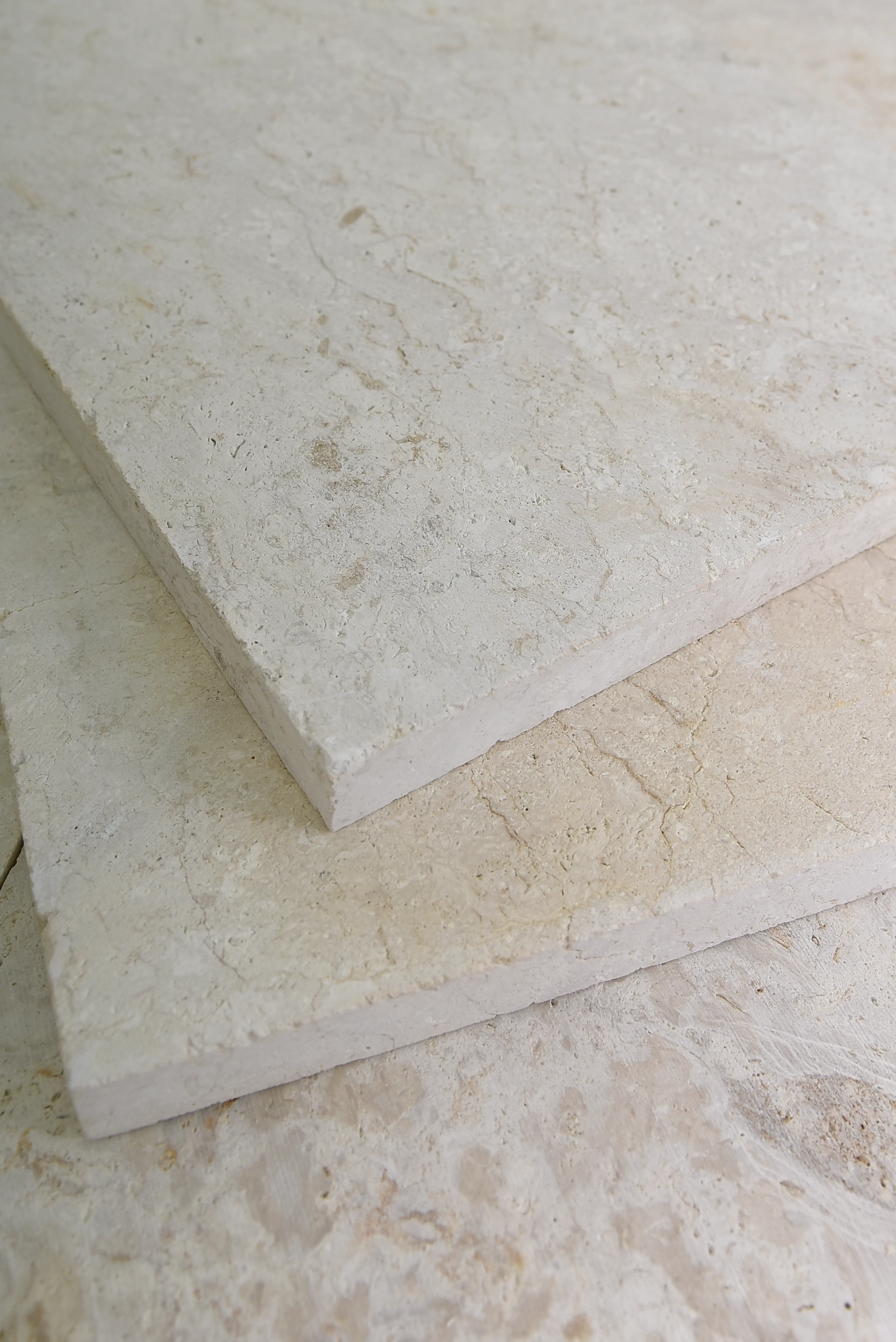 Textured Beige Stone Slabs Close-up view of light beige limestone slabs with natural texture and subtle veining, an example for global marble and granite importers.