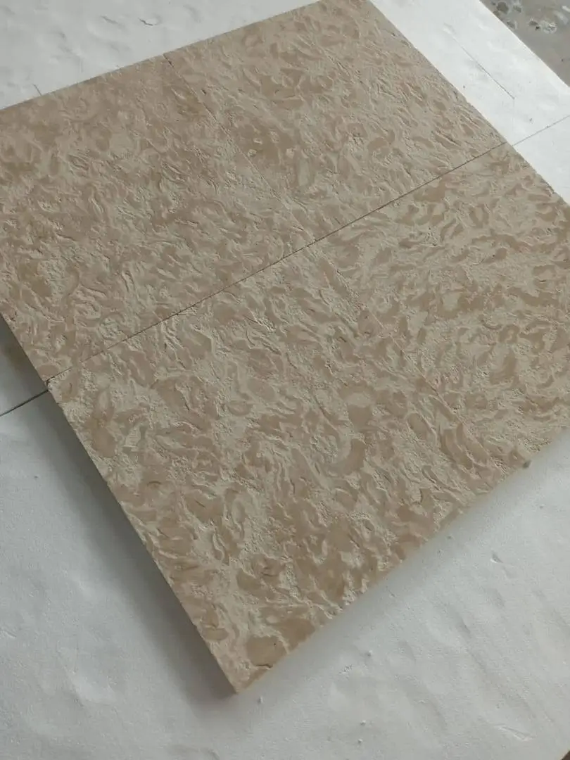 Textured Beige Stone Tiles Laid Out Close-up of beige travertine tiles showcasing natural wavy patterns and texture, an example for white granite outdoor.