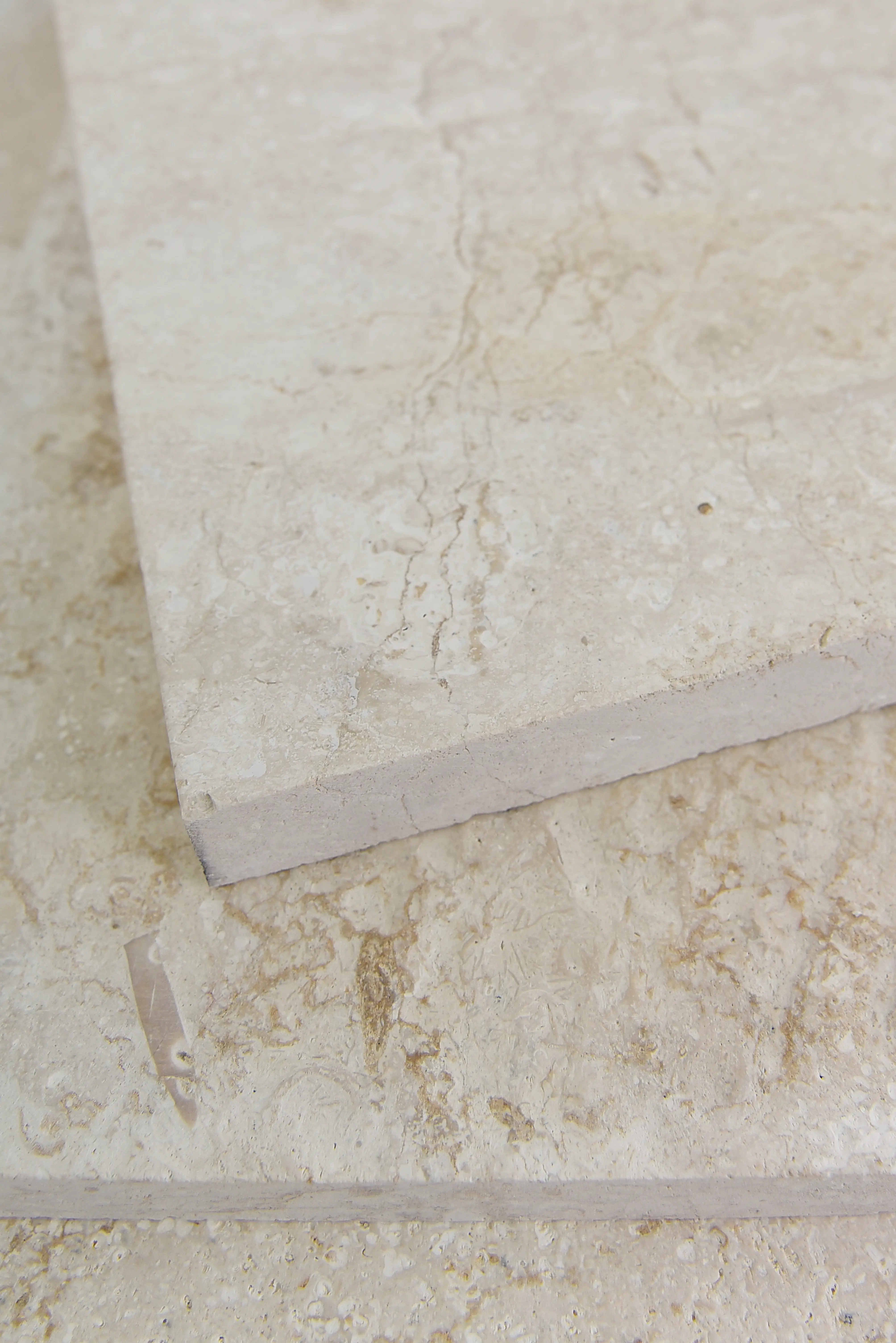 Travertine Stone Texture Close-Up Close-up view of travertine tile showcasing its natural light beige color and veining, pictured for wood tile floor.