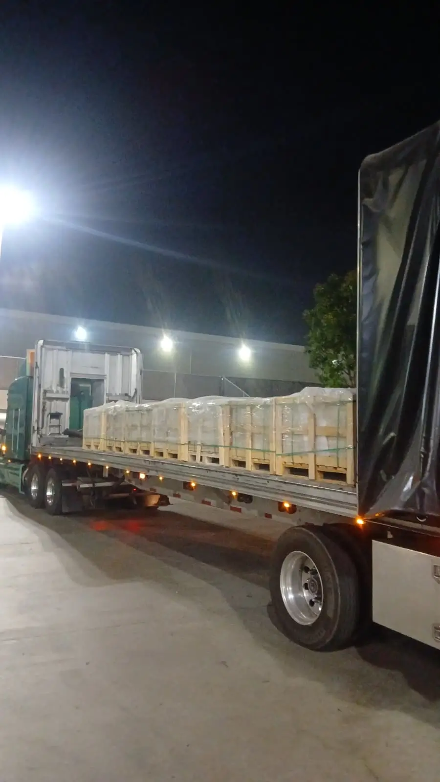 Flatbed truck carrying wrapped wooden pallets of stone blocks, an example for making flagstone walkway.