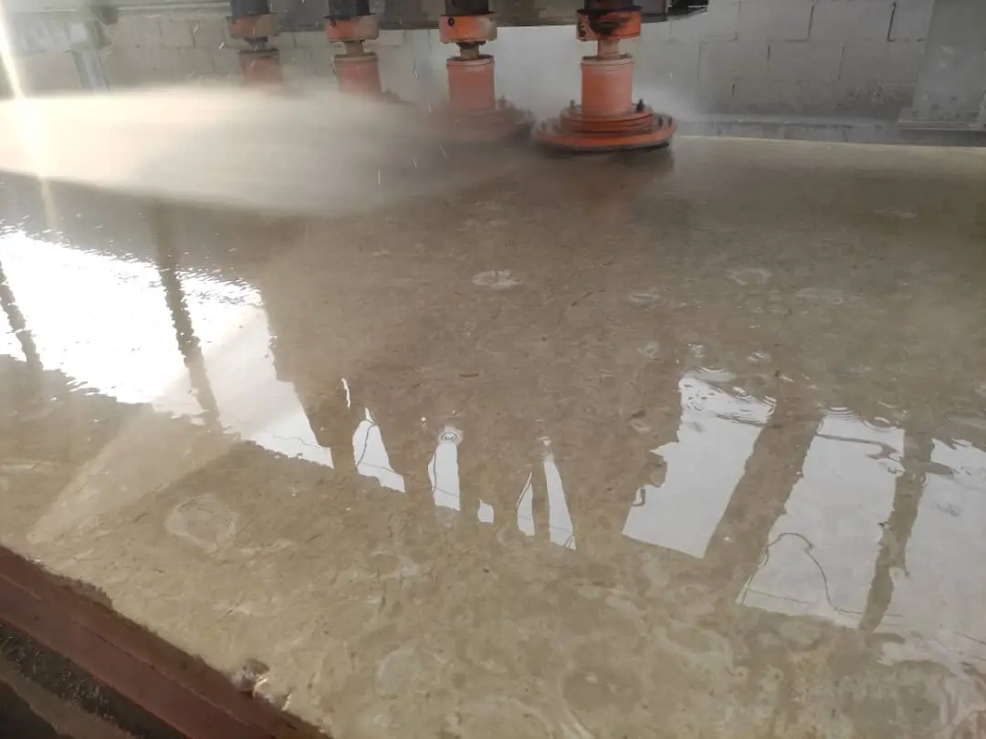 Polished granite surface being wet processed by a multi-head polishing machine, an example for stone steps for patio.