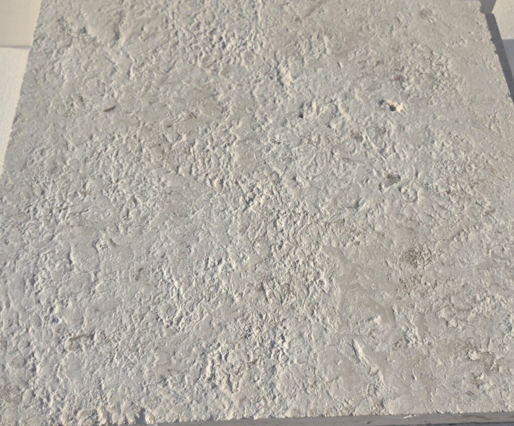 Close-up of 16 grit brushed antiqued limestone showing deep rustic texture