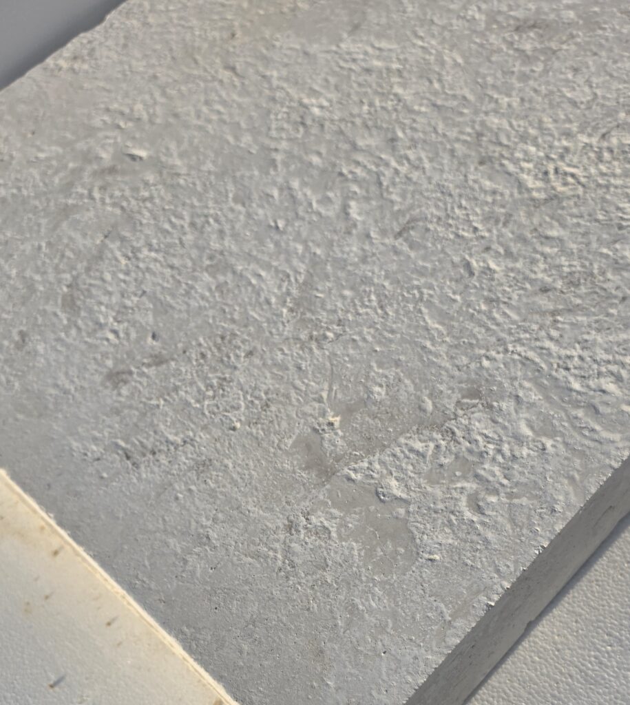 Surface detail of 36 grit brushed antiqued limestone