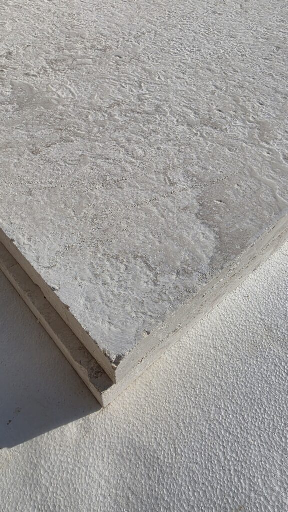 Corner of an 80 grit brushed limestone slab showing thickness