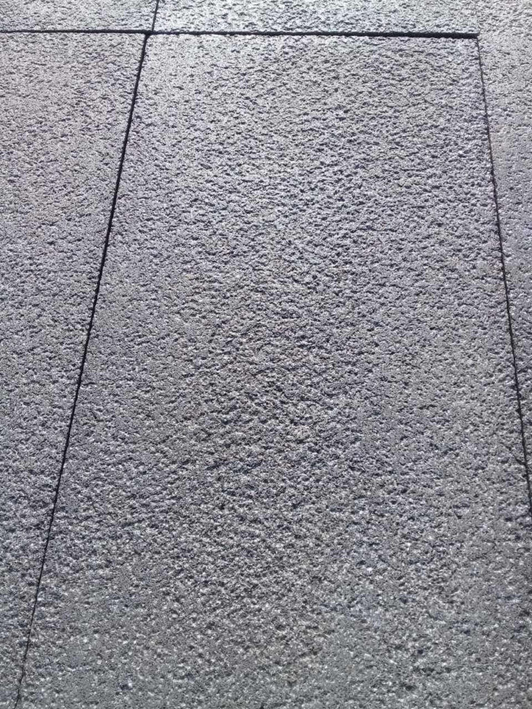 Bush-hammered black basalt pavers installed outdoors