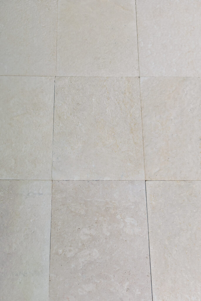Grid of double-brushed 24 grit limestone floor tiles seen from above