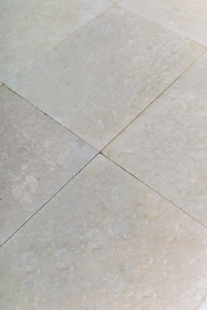 Raking light across double-brushed 24 grit limestone showing the rounded relief