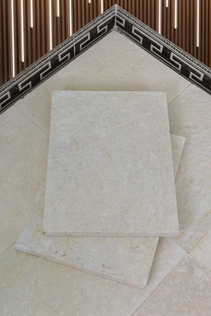 Corner of a double-brushed 60 grit limestone tile with mosaic border