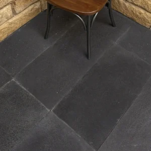 Coarse brushed grey basalt pavers with mineral flecks, shown dry