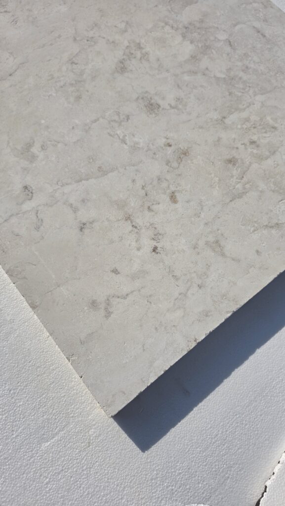 Corner of a 120 grit honed limestone slab in natural light
