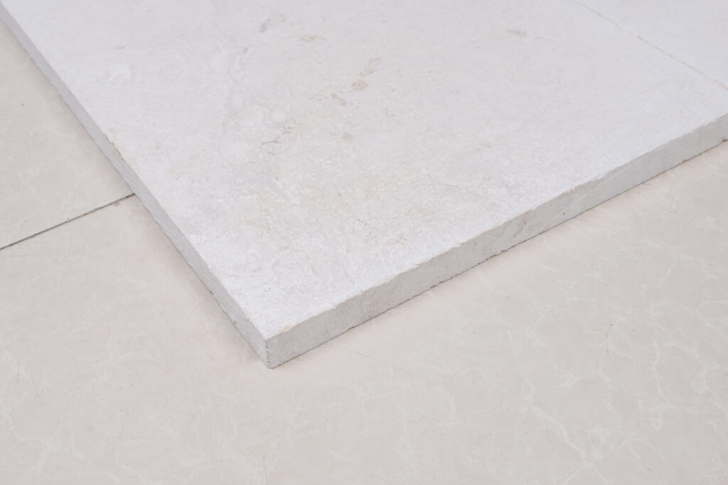Polished white limestone slab corner showing crisp edge and reflective face
