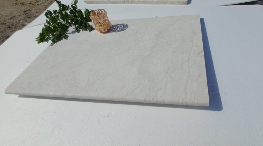 Polished white limestone tiles in a styled display