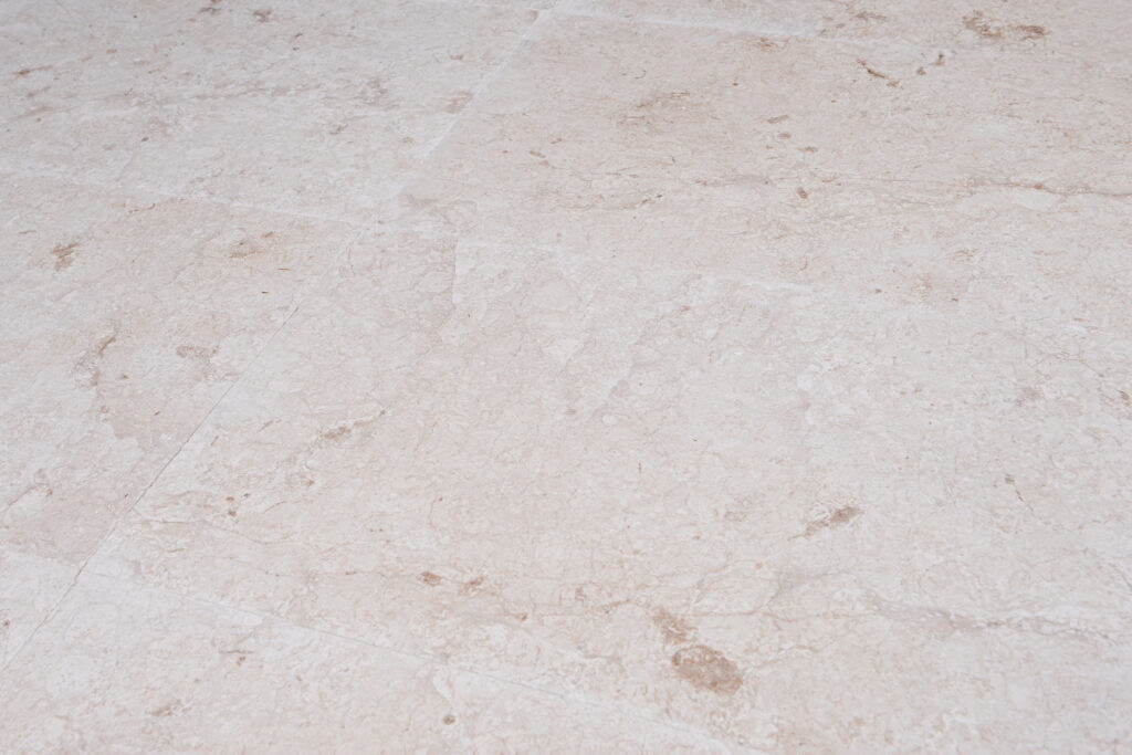 Polished white limestone tiles laid as flooring in natural light