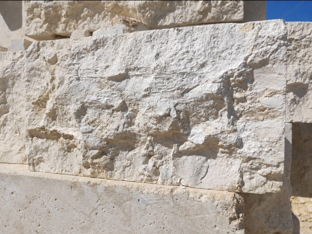 Close-up of a split-face stone panel showing the natural cleft texture in sunlight