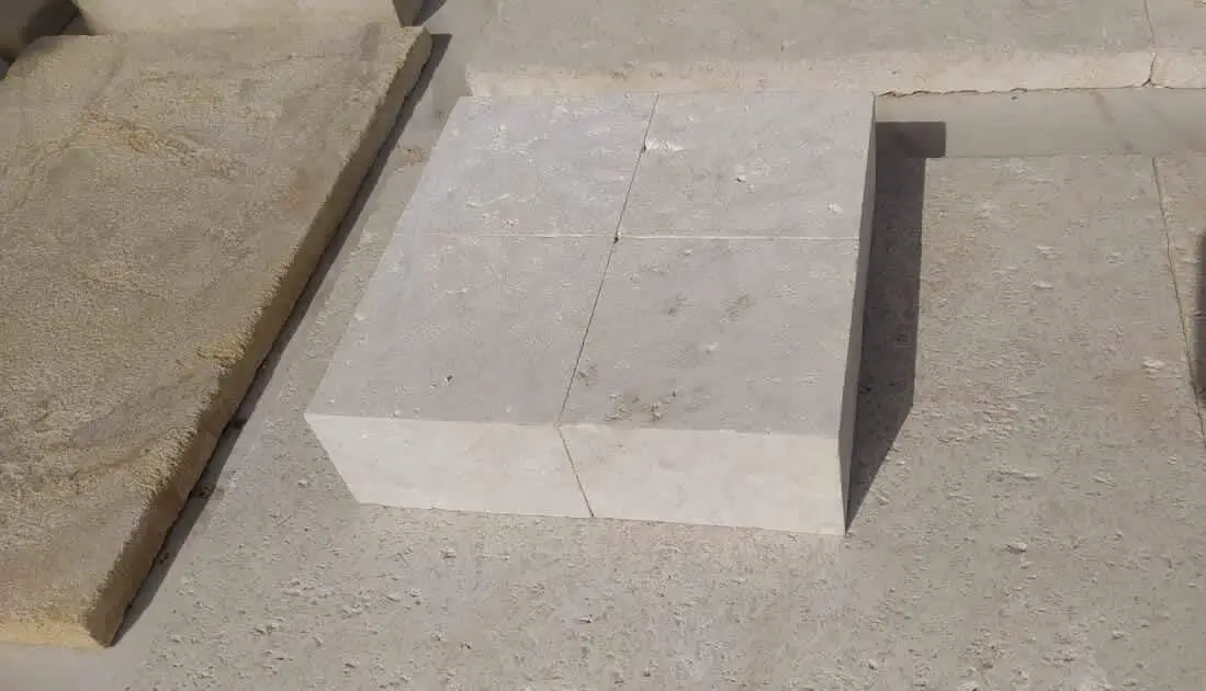Four light beige cobblestone blocks are stacked and cut, showcasing a precise quarry finish, a reference for cobblestone pavers for patio.
