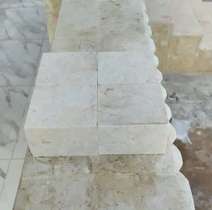 Close-up of light-colored stone blocks showcasing their textured surface and clean edges, relevant to permeable cobblestone pavers.