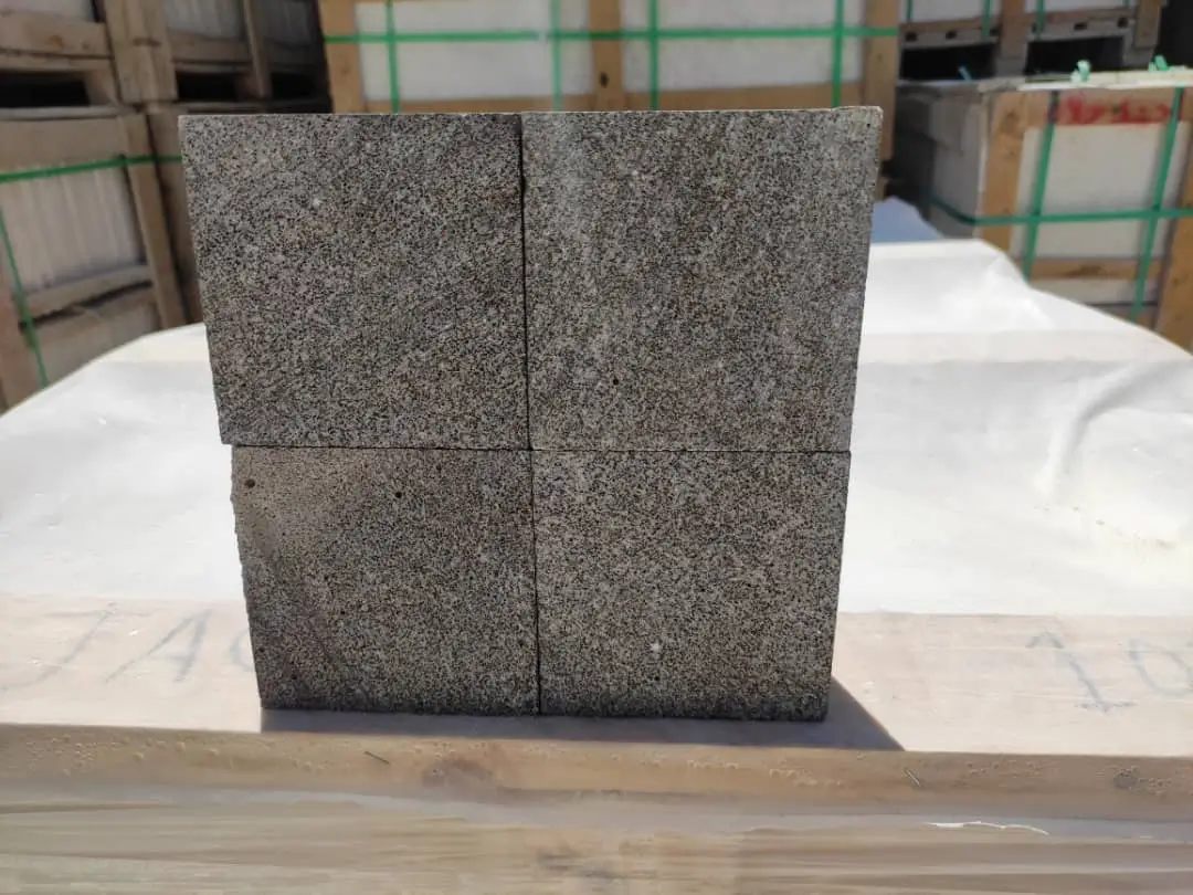 Stack of four grey cobblestone pavers with visible aggregate texture