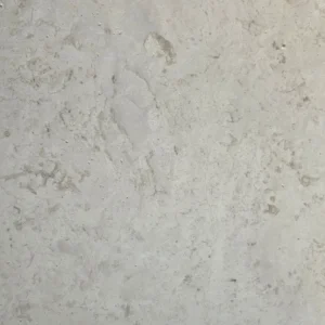 Close-up of Crema Argento honed limestone surface with brown-grey mottling, fine natural pores and a satin-matte finish