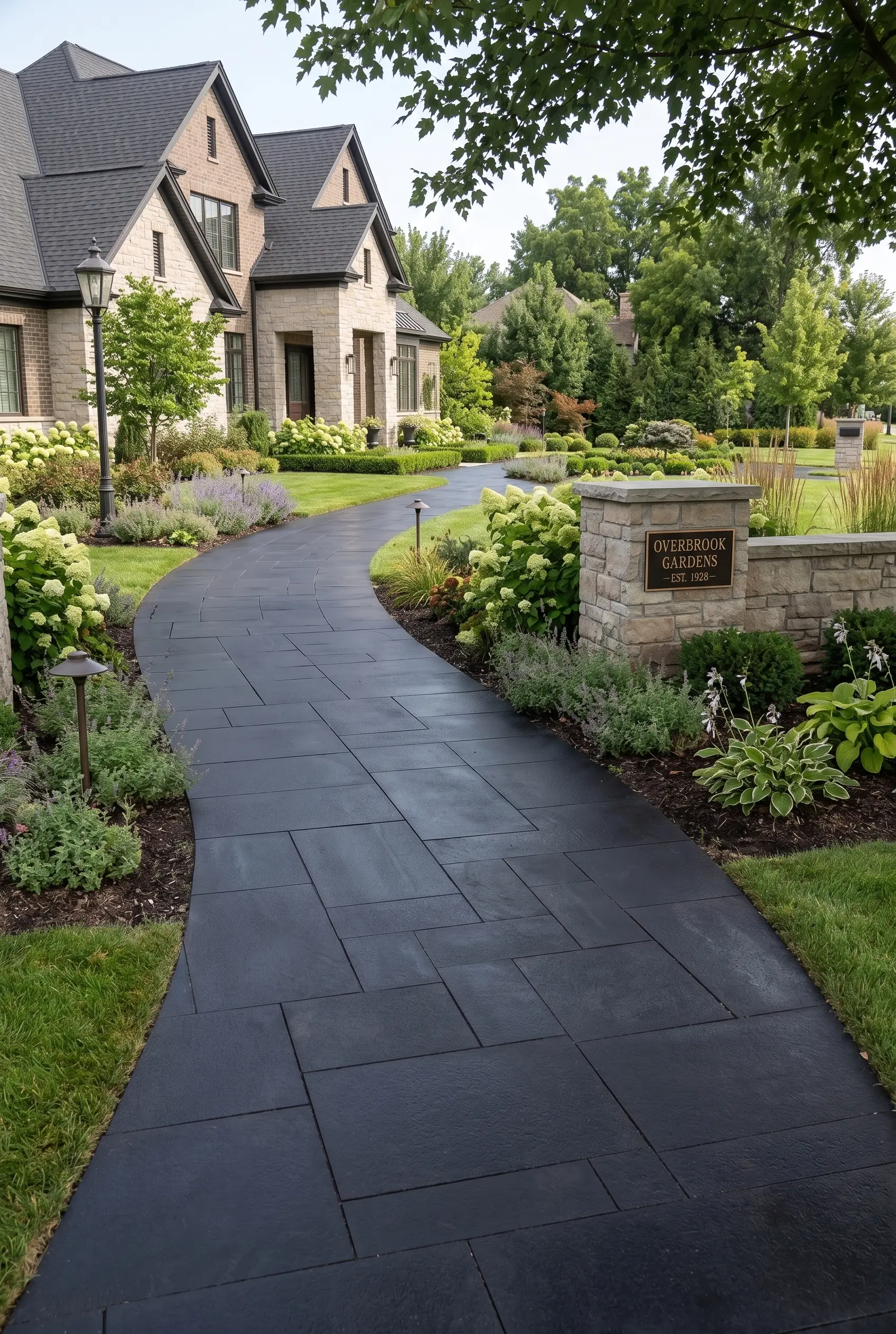 Curved walkway of dark gray basalt pavers leads through a manicured garden.