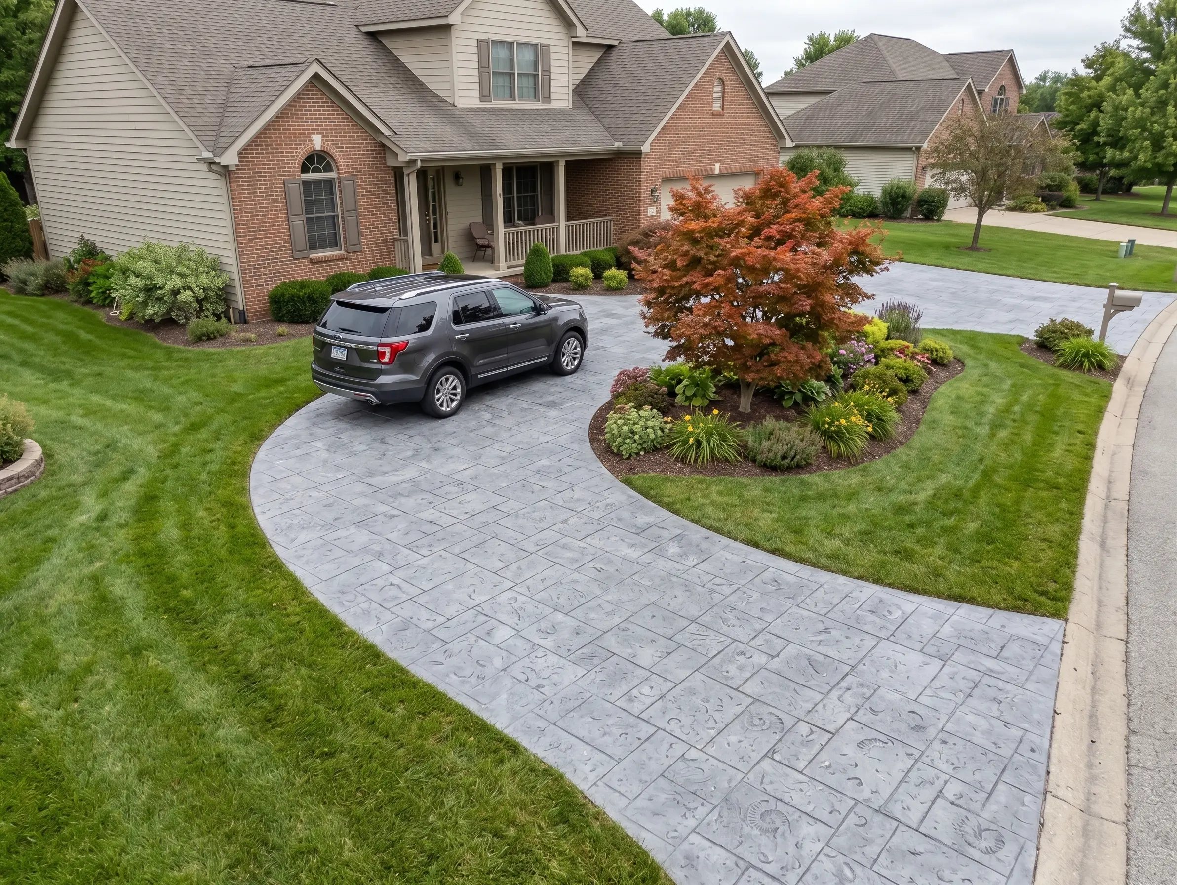 A gray SUV parked on a curved driveway made of stamped concrete pavers.