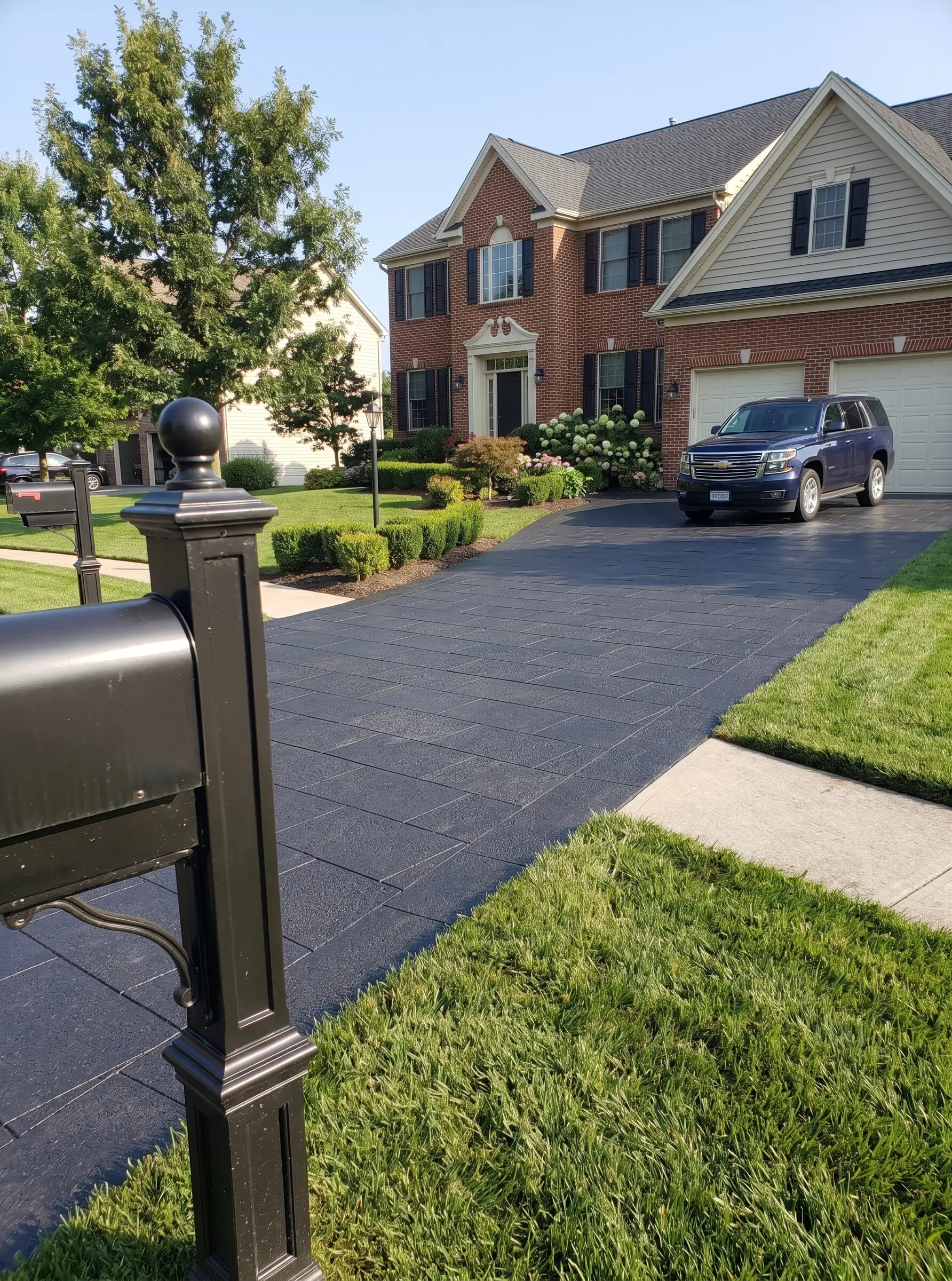 Dark Stamped Concrete Driveway with Grass Dark basalt stone surface showing the dense, fine-grained texture typical of volcanic rock used in paving and landscaping.