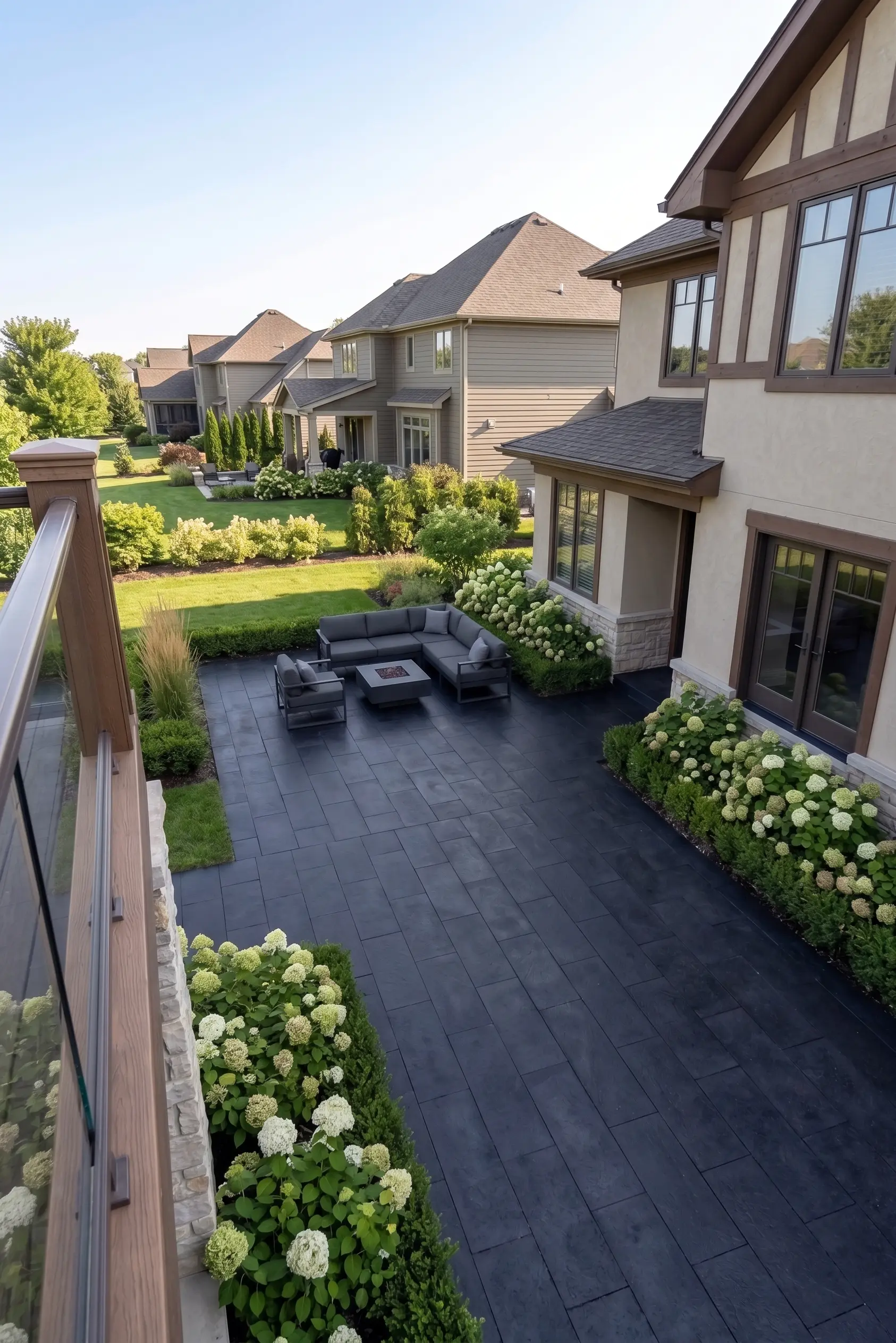 Dark stone patio with modern outdoor furniture and hydrangea bushes, suitable for basalt projects.
