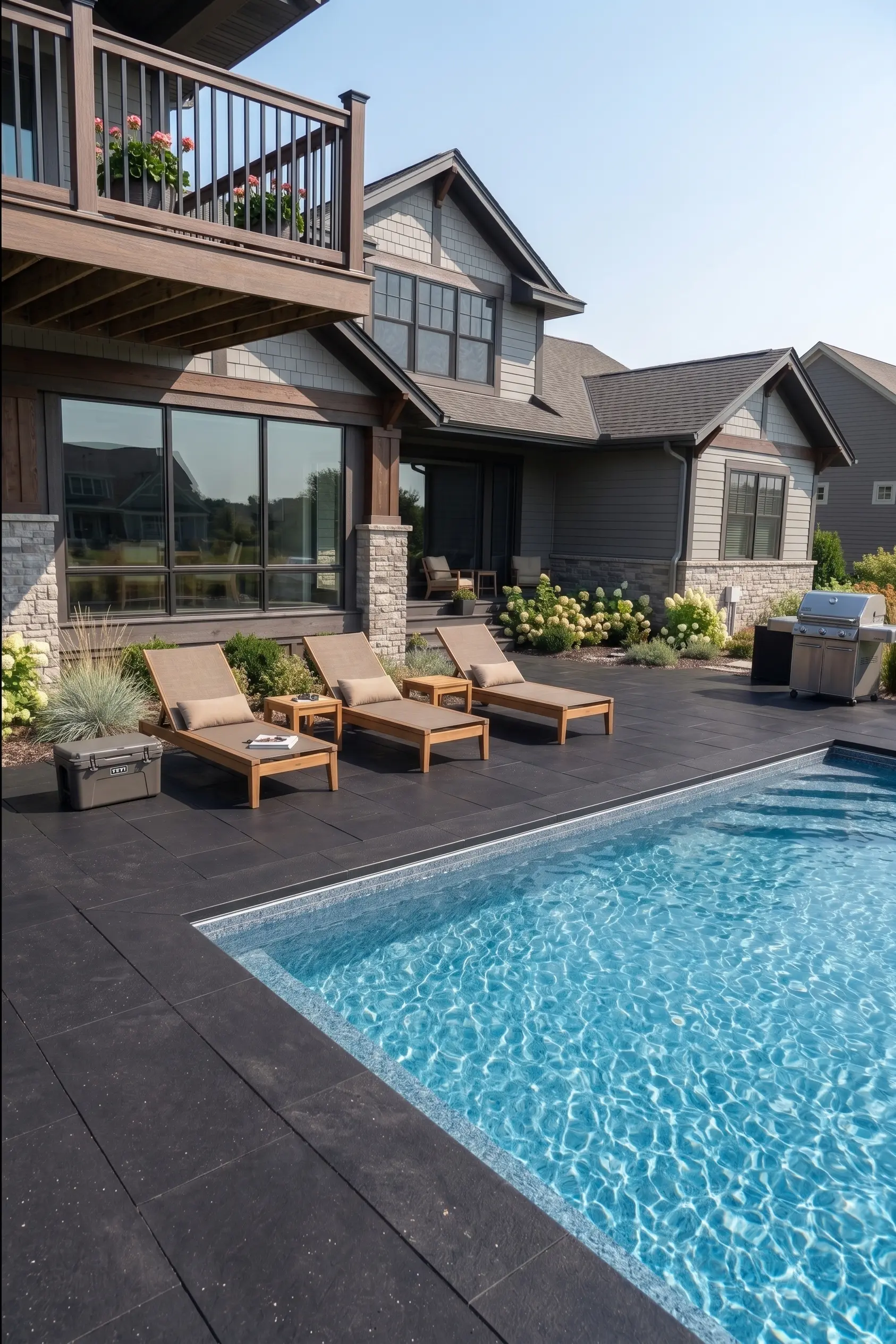 Dark granite pavers surround a bright blue swimming pool, showing their thickness visually