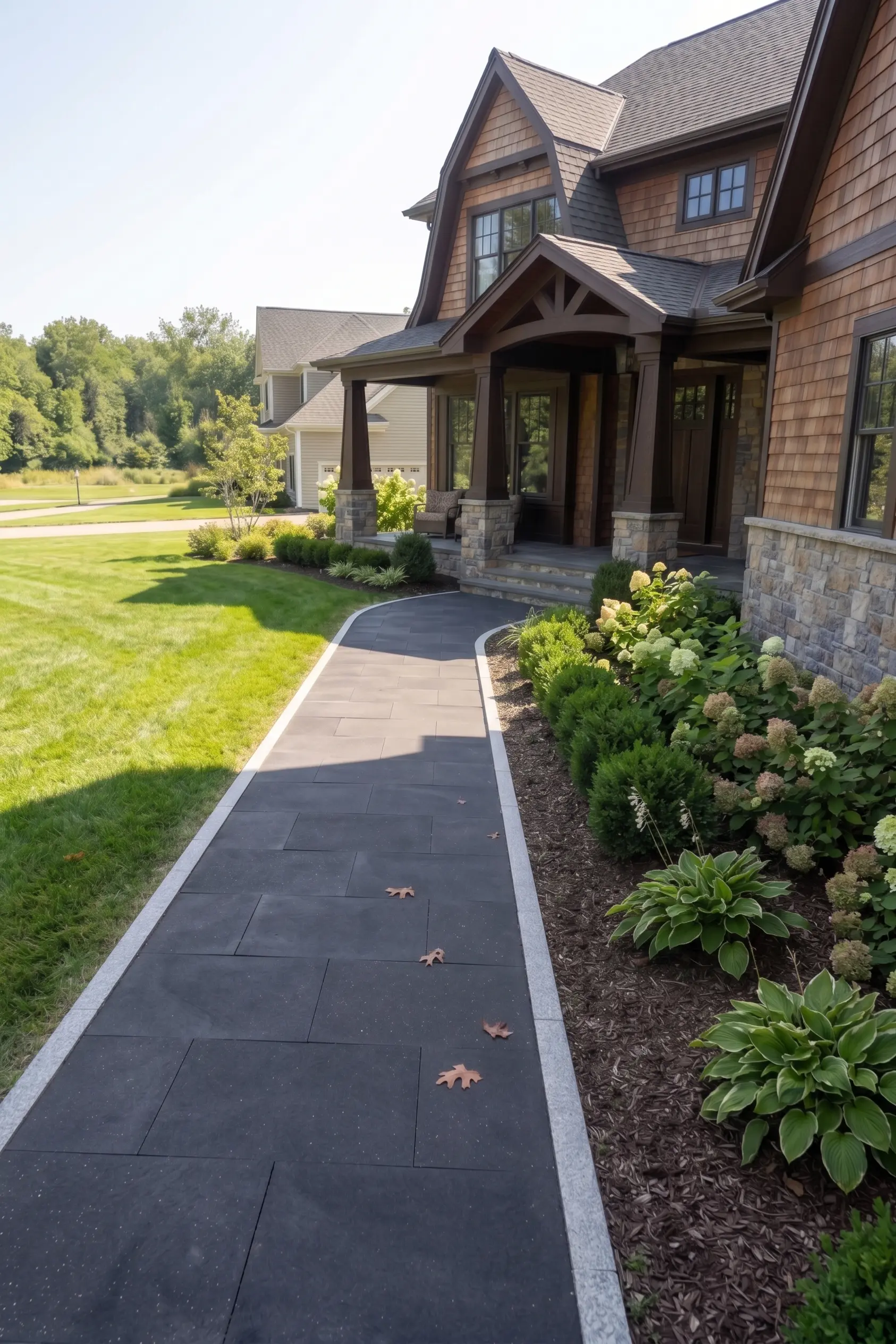 Dark granite pavers form a curving walkway beside lush green landscaping
