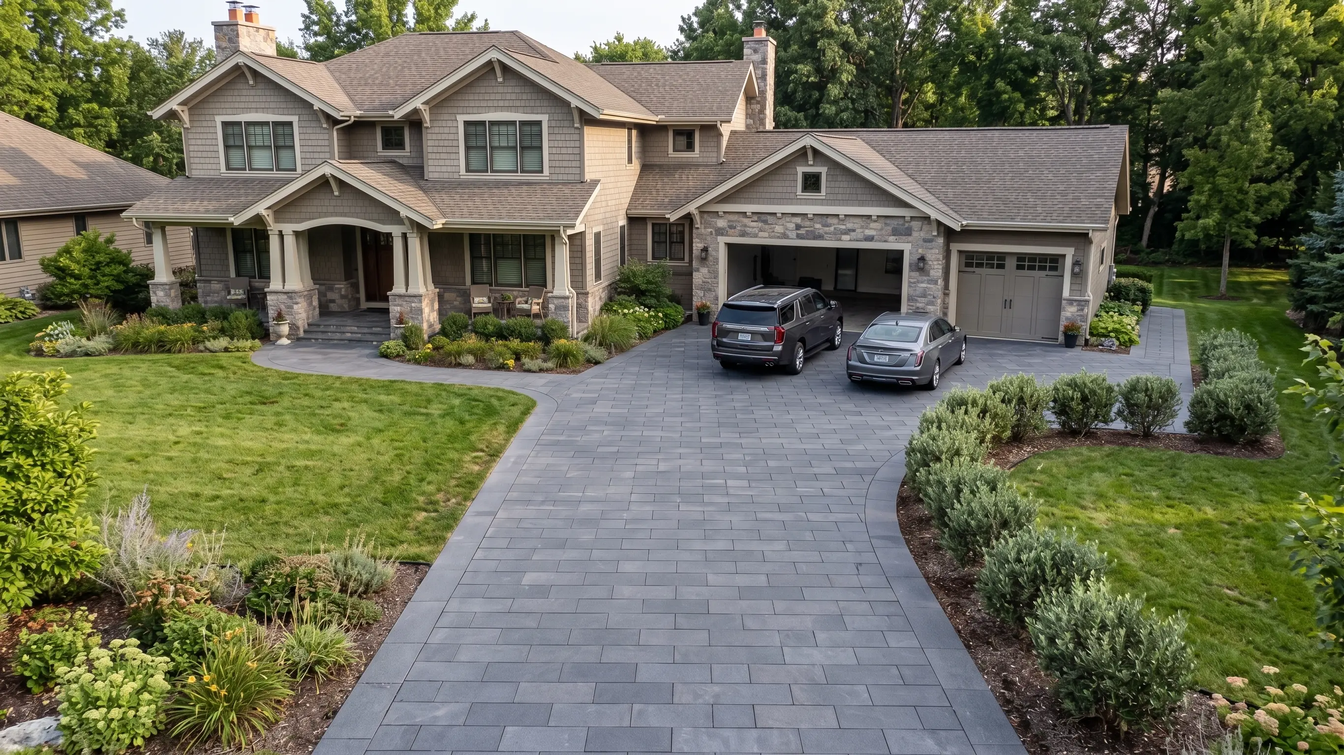 Modern house with dark basalt pavers and manicured landscaping.