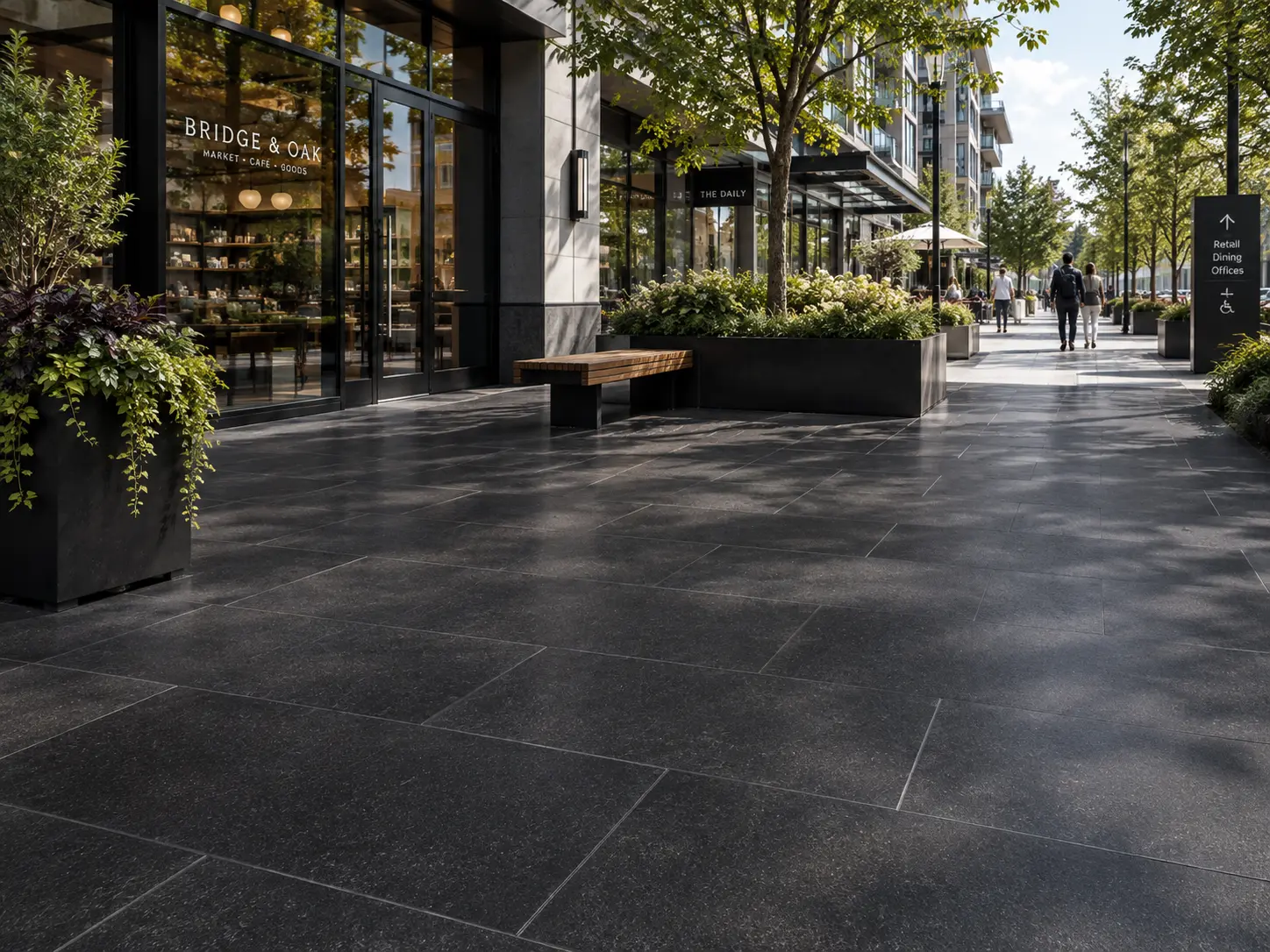 A dark, speckled basalt slab walkway in front of modern storefronts.