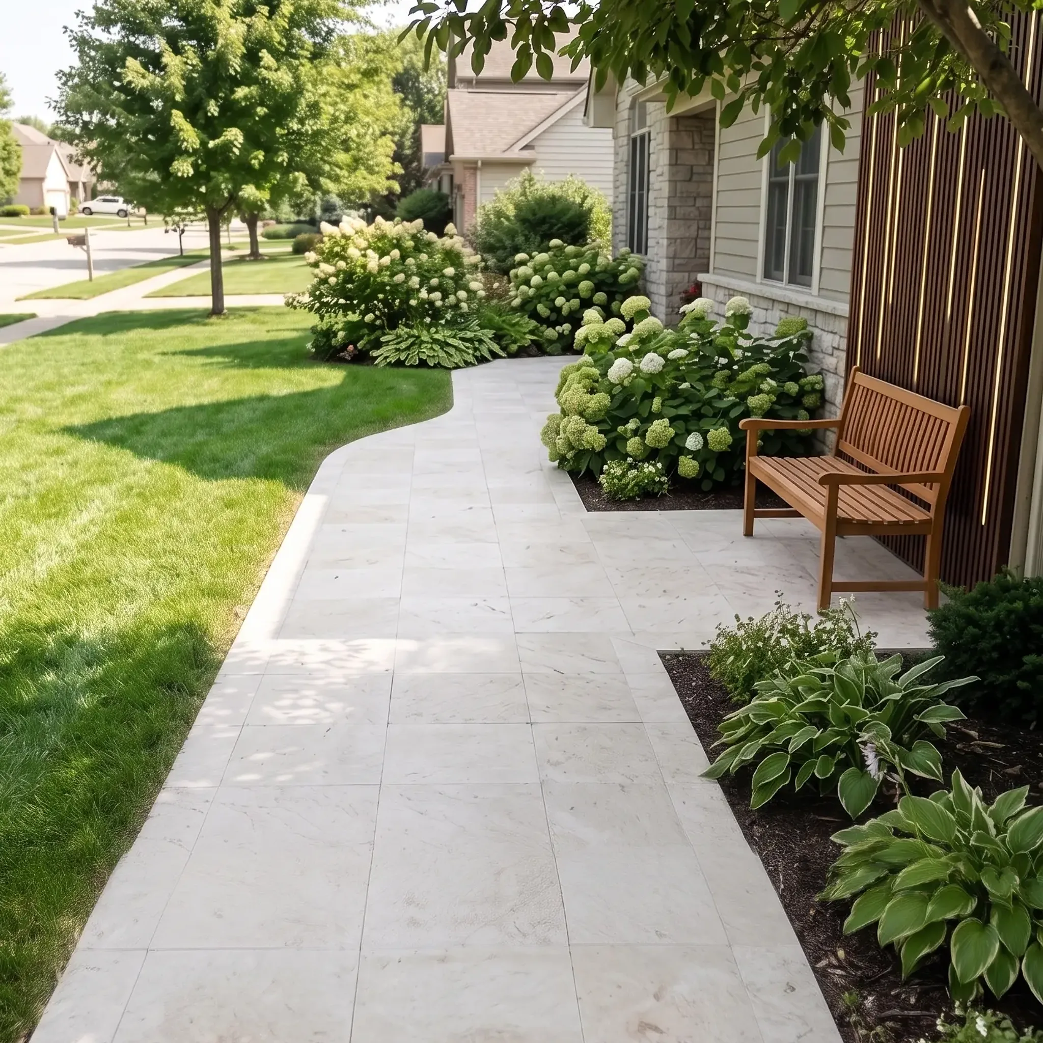Curved front walkway of white veined stone pavers past a teak bench, hydrangeas, hostas and a modern house with wood…